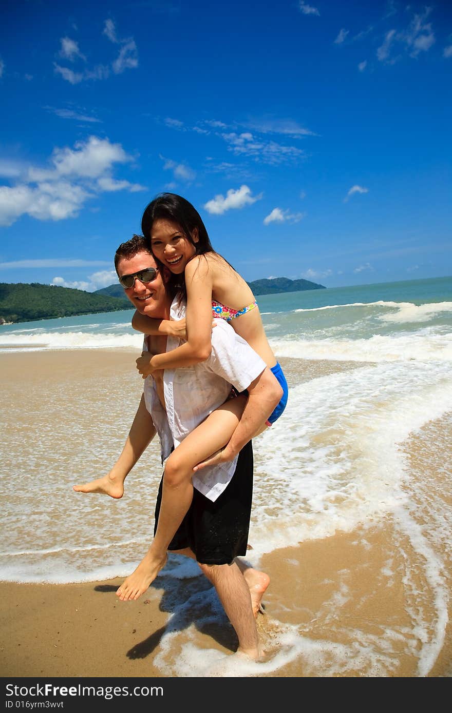 Portrait of a happy young couple having fun on the beach. Couple enjoying a summer vacation. Portrait of a happy young couple having fun on the beach. Couple enjoying a summer vacation.