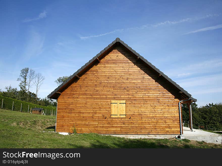 Wooden chalet in green garden and blue sky, Correze, France. Wooden chalet in green garden and blue sky, Correze, France