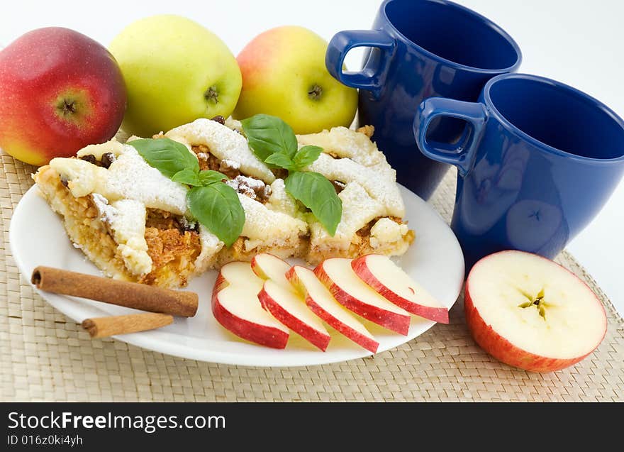 Apple pie on the plate with apples in the background