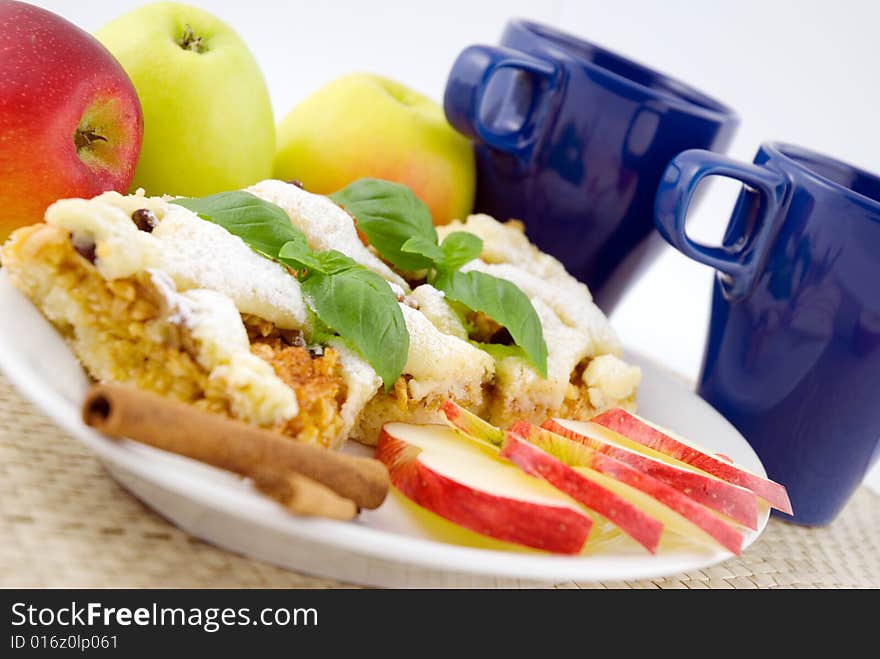 Apple pie on the plate with apples in the background