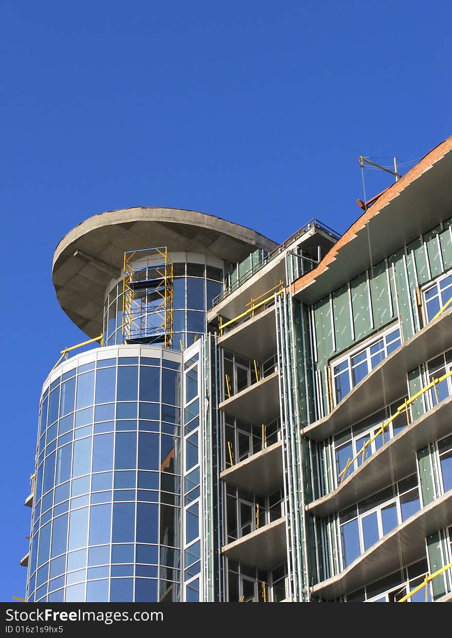 The modern house is Built. He sparkles all window under sun, on background blue sky. The modern house is Built. He sparkles all window under sun, on background blue sky.