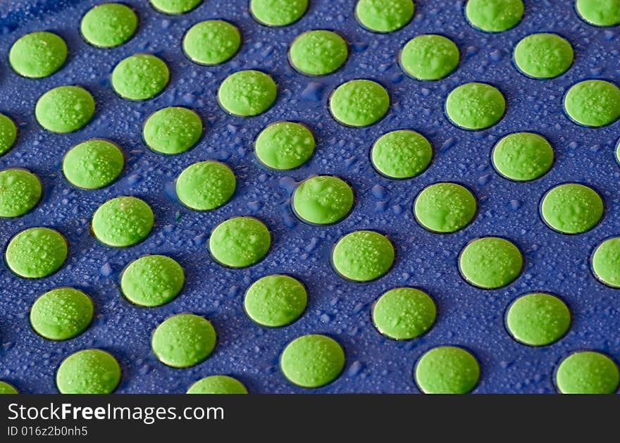 Bright green donts on a childs chair with drops of water. Bright green donts on a childs chair with drops of water