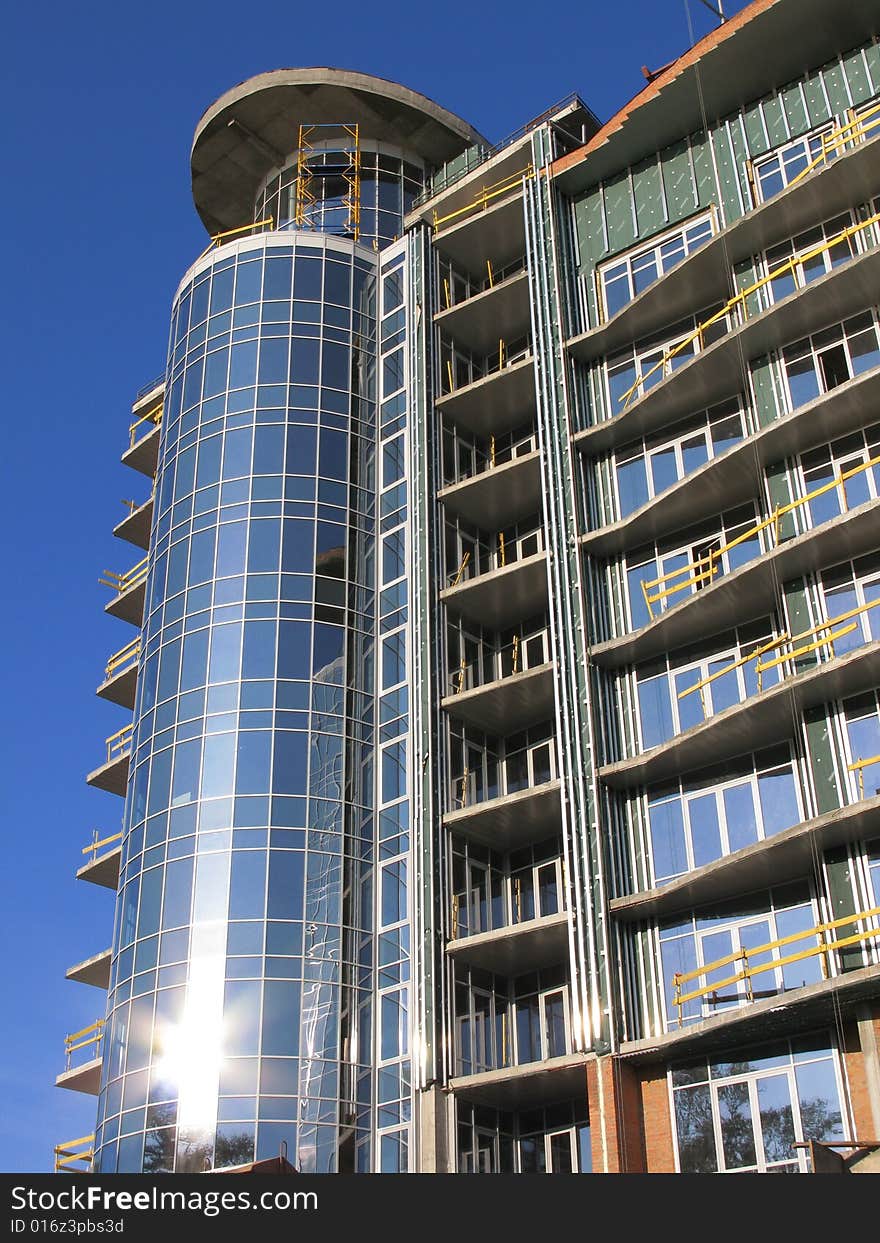 The modern house is Built. He sparkles all window under sun, on background blue sky. The modern house is Built. He sparkles all window under sun, on background blue sky.