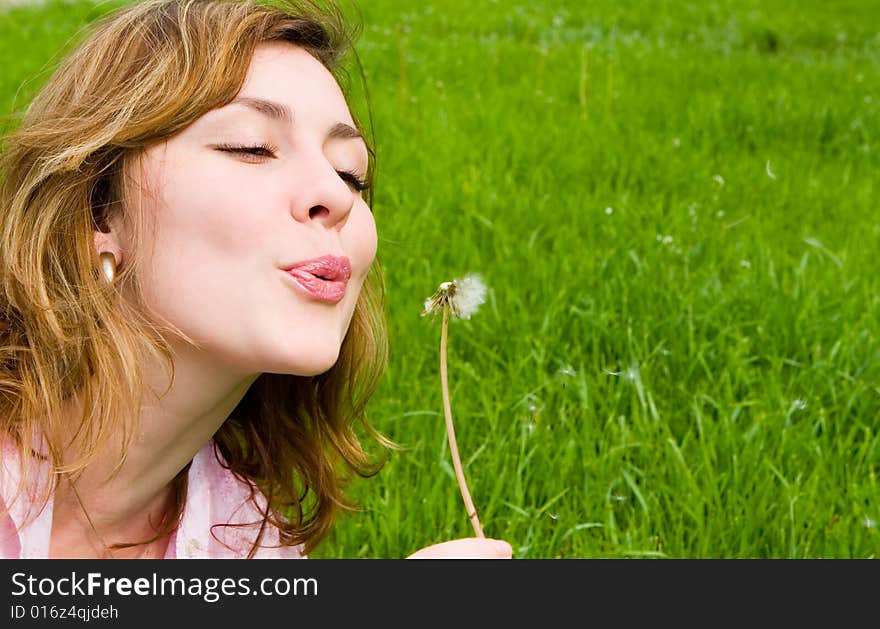 Girl blowing on the dandelion