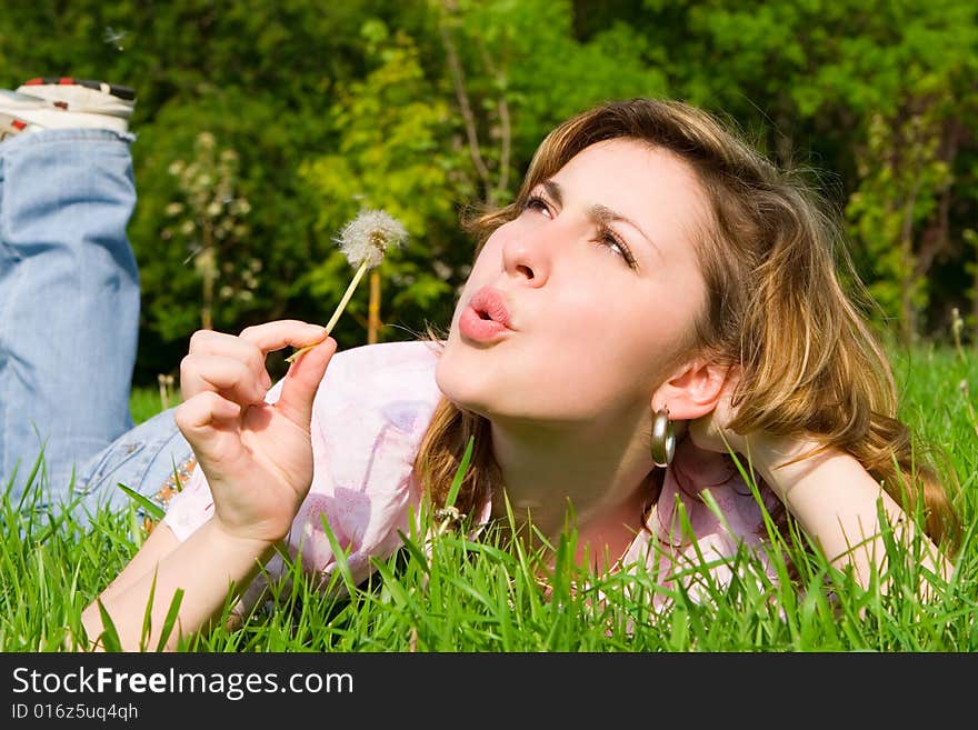 Young girl blowing on the dandelion