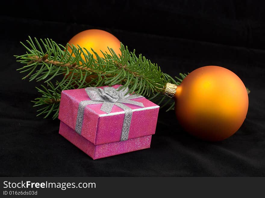 Two yelow christmas balls with present on the black background