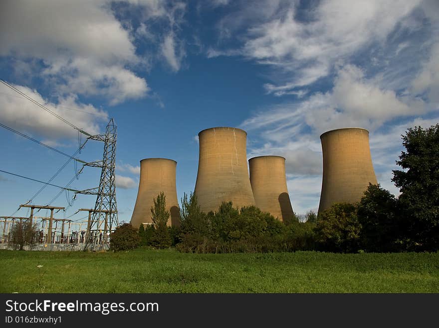 The cooling towers of a power station against a blue sky. The cooling towers of a power station against a blue sky