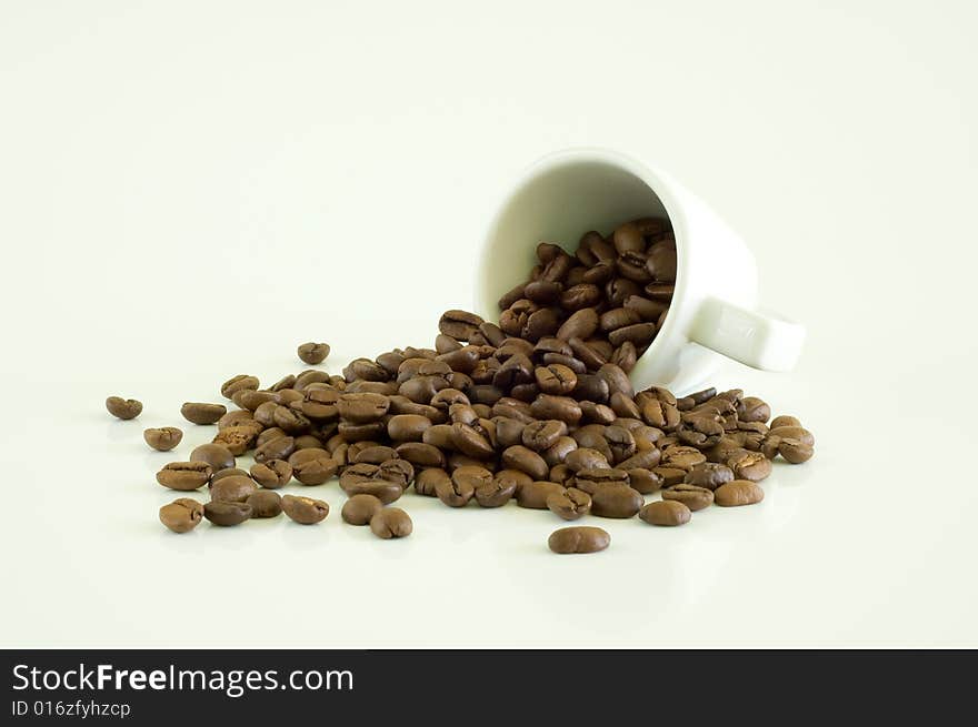 White coffee cup and coffee beans on a light background