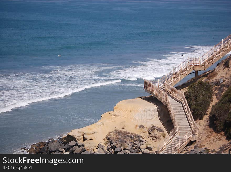 A little cliff that goes down into the ocean.