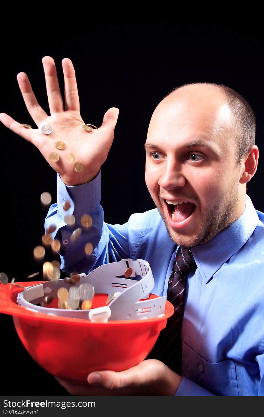 Man in a shirt and a tie fills coins, on a black background. Man in a shirt and a tie fills coins, on a black background