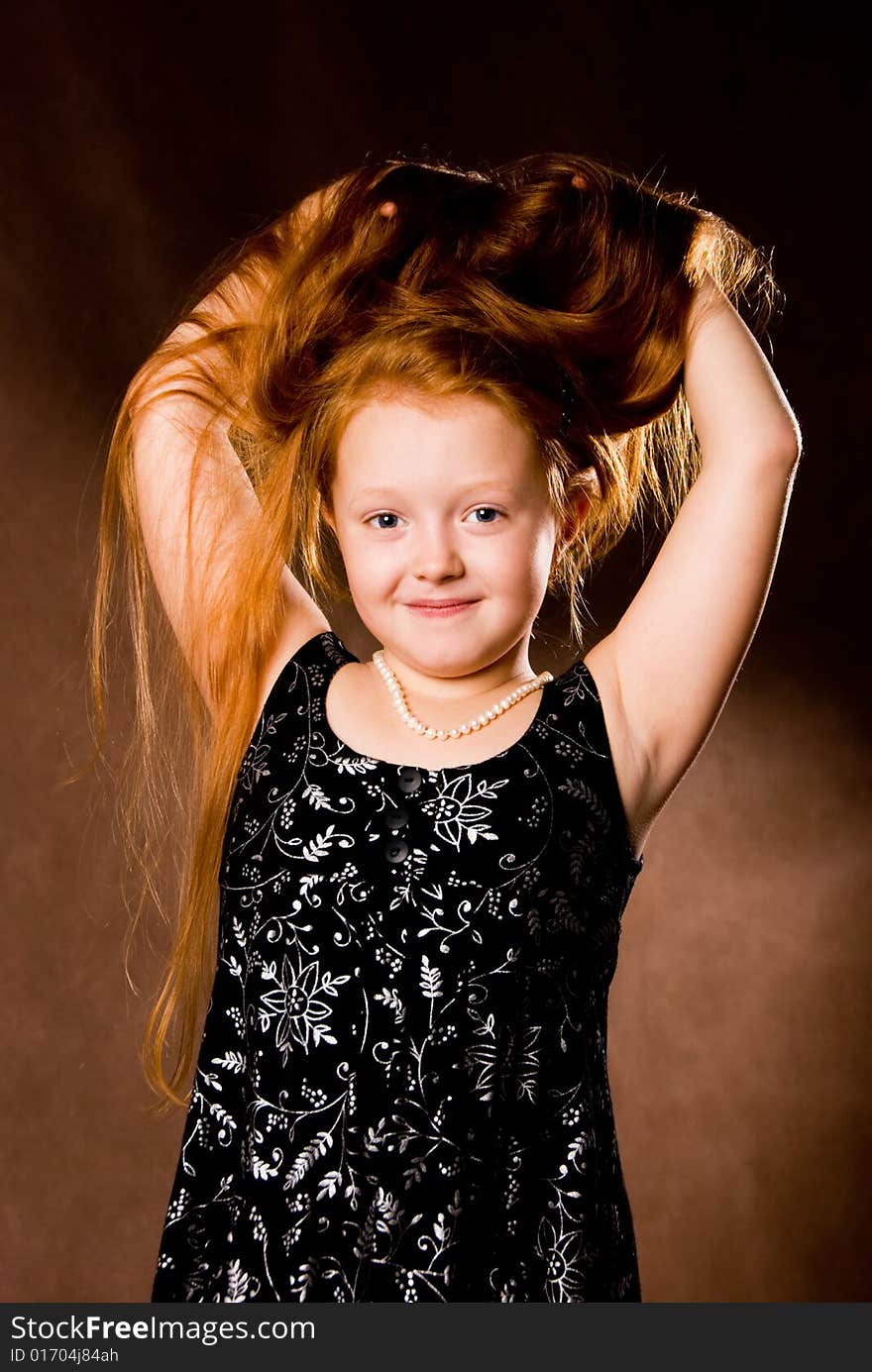 Beautiful little girl with luxurious ginger hair