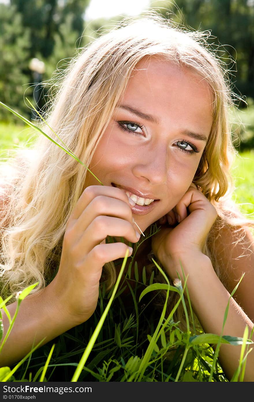 Young blond woman smiling in a park. Young blond woman smiling in a park