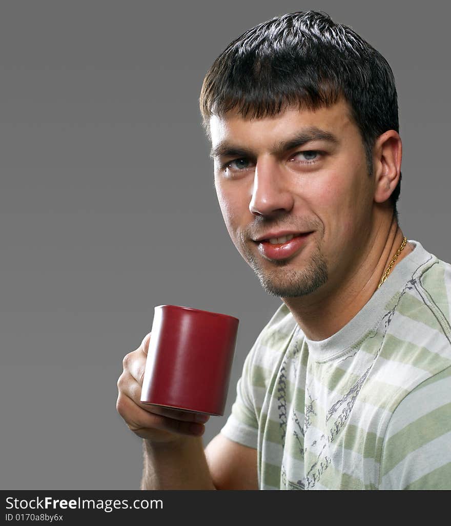 Young handsome brunet holding a cup of something, smiling. Young handsome brunet holding a cup of something, smiling