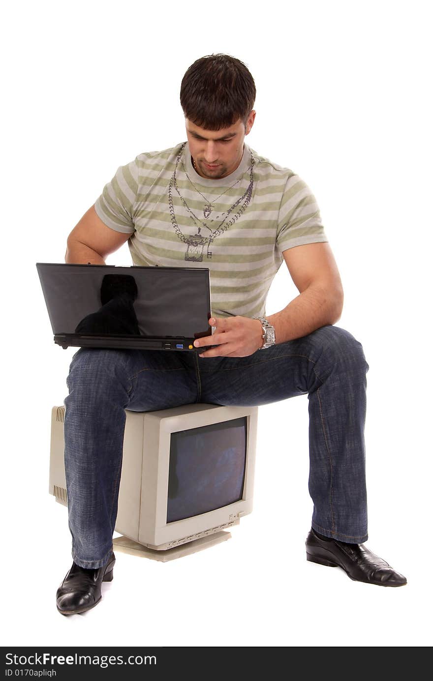 Contemporary young guy sitting on an old-fashioned computer and working with laptop, isolated on white background. Contemporary young guy sitting on an old-fashioned computer and working with laptop, isolated on white background