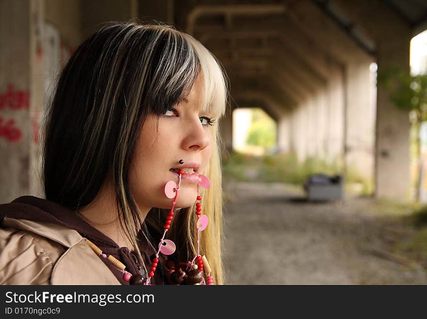 Beautiful young woman, fashion model, black and blond hair in industrial location