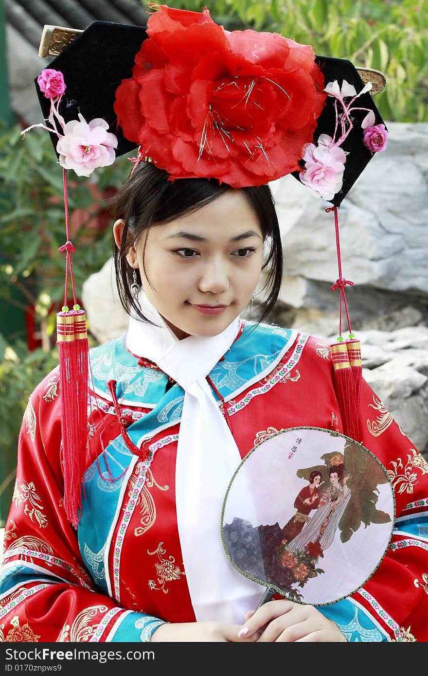 Portrait of a beautiful girl in Chinese ancient dress. 
Chinese on the fan is meant and missed. Portrait of a beautiful girl in Chinese ancient dress. 
Chinese on the fan is meant and missed.