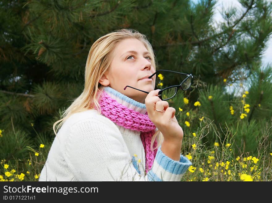 The girl sits on a lawn   in an environment of yellow colours. The girl sits on a lawn   in an environment of yellow colours