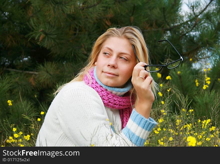 The girl sits on a lawn   in an environment of yellow colours. The girl sits on a lawn   in an environment of yellow colours