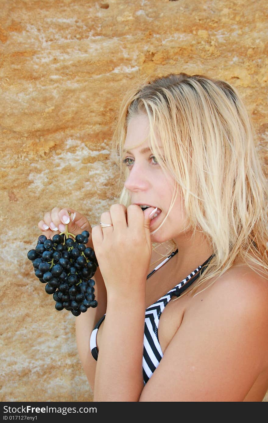 The girl the blonde eats black grapes. The girl the blonde eats black grapes