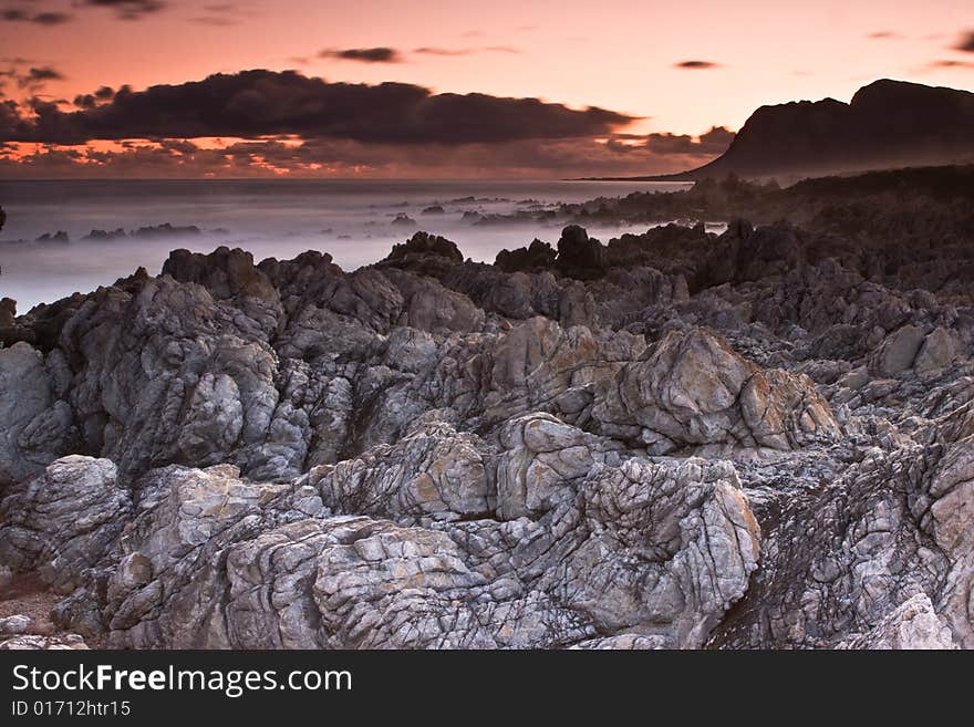 Sunset over the Bettys Bay rocky beach. Sunset over the Bettys Bay rocky beach