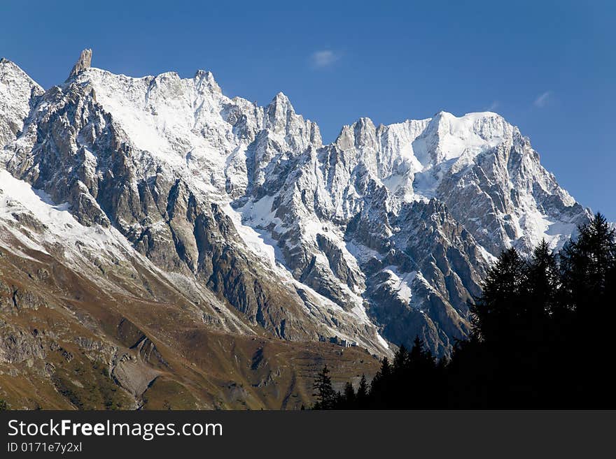 Autumn view of snowcapped peaks in an alpine valley. Gran Jourasses (Mont Blanc massif), Val Veny, Courmayeur, Italy. Autumn view of snowcapped peaks in an alpine valley. Gran Jourasses (Mont Blanc massif), Val Veny, Courmayeur, Italy.