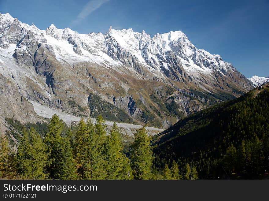 Autumn view of snowcapped peaks in an alpine valley. Gran Jourasses (Mont Blanc massif), Val Veny, Courmayeur, Italy. Autumn view of snowcapped peaks in an alpine valley. Gran Jourasses (Mont Blanc massif), Val Veny, Courmayeur, Italy.