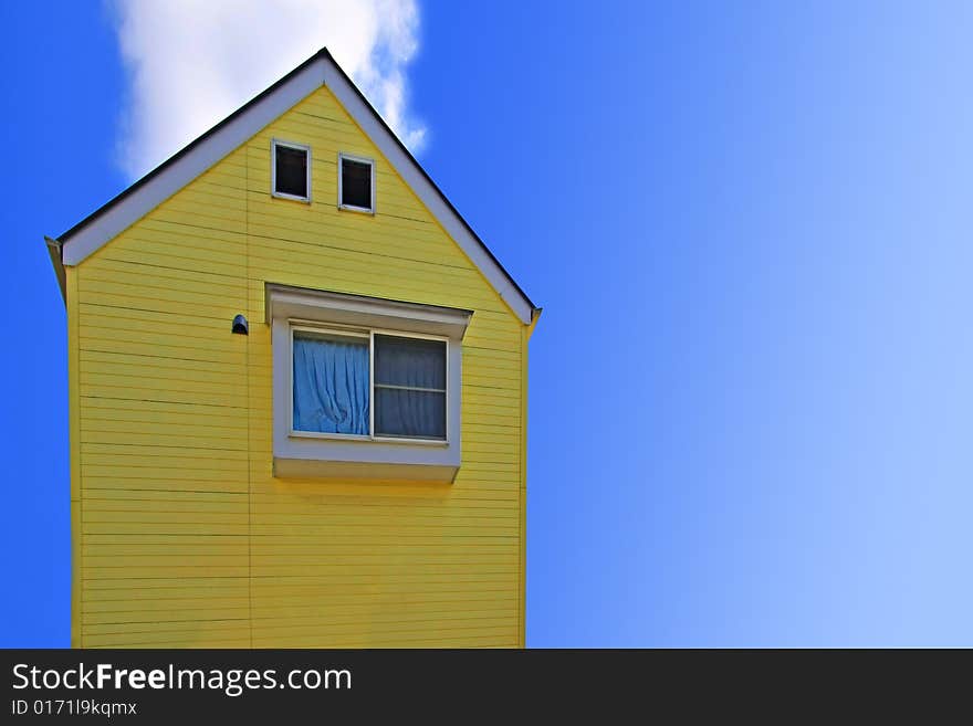 Yellow house against a bright blue sky.