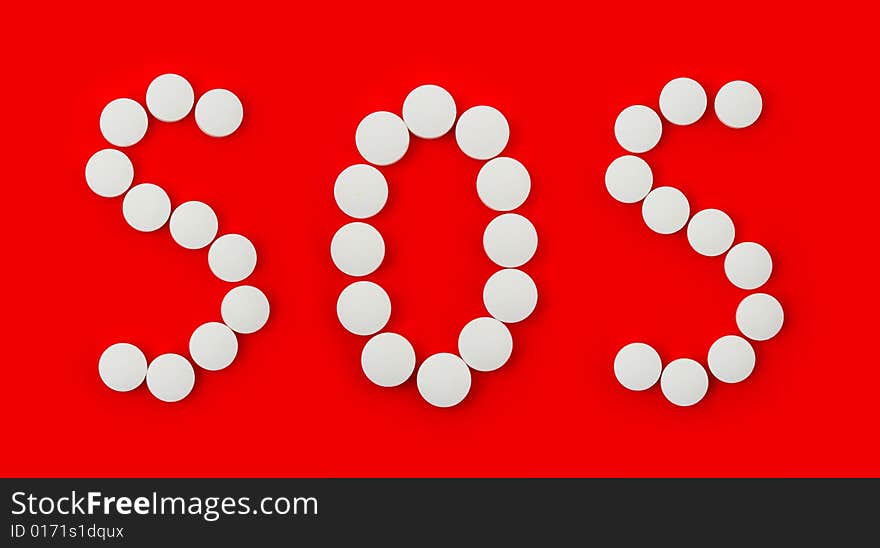 Word SOS made of pills isolated on red background