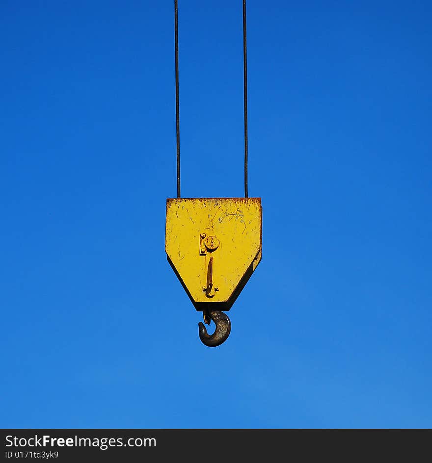 Yellow crane hook isolated on blue sky