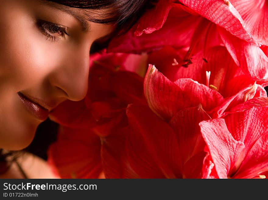 Nice smiling girl is smiling and red flowers. Nice smiling girl is smiling and red flowers