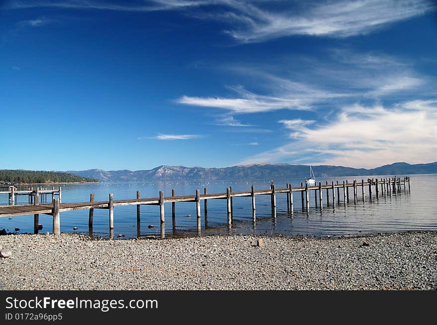 Private pier into the water of Lake tahoe on a clear day with blue sky. Private pier into the water of Lake tahoe on a clear day with blue sky