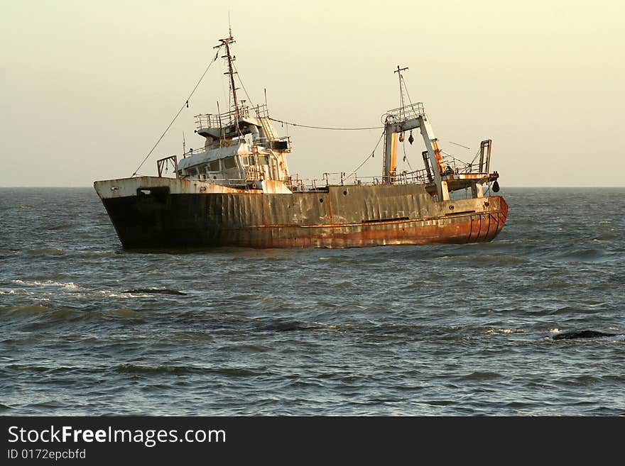 Shipwreck at sunset in ocean