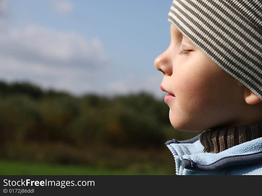 Young boy enjoying sun in autumn