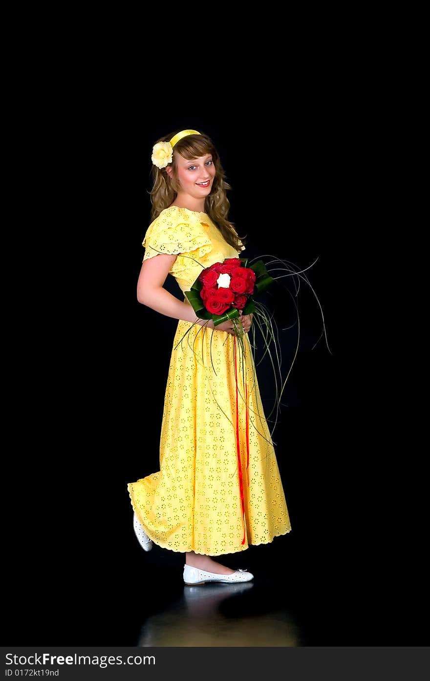 Portrait of a beautiful young bride showing her wedding bouquet of red and white roses on black background, studio shot. Portrait of a beautiful young bride showing her wedding bouquet of red and white roses on black background, studio shot