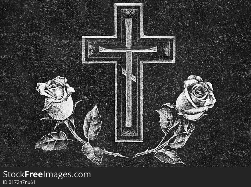 Cross and roses on a dark granite gravestone