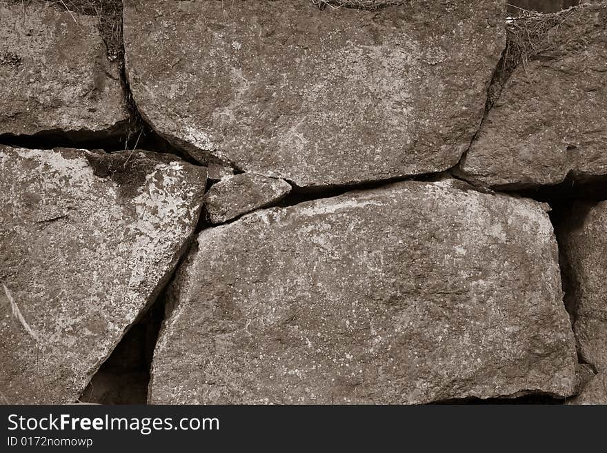 Aged stone wall background sepia toned