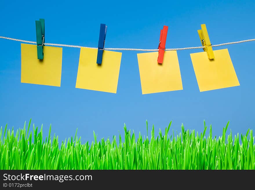 Four different post it hanging out with colorful pegs in a sunny day. Write it on whatever you want!. Four different post it hanging out with colorful pegs in a sunny day. Write it on whatever you want!