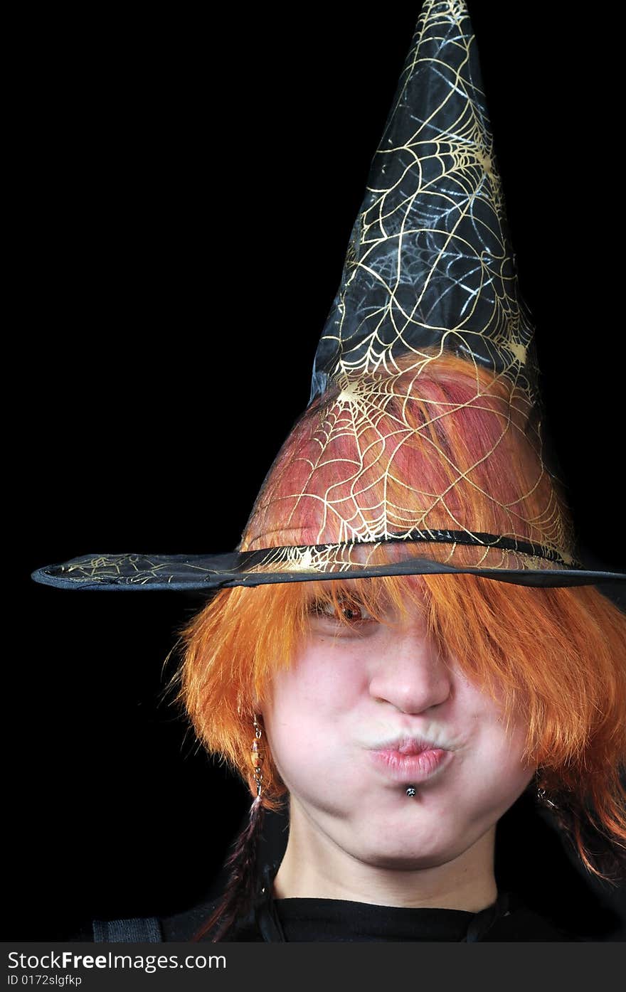 Redhair scarecrow in wizard's hat on black background