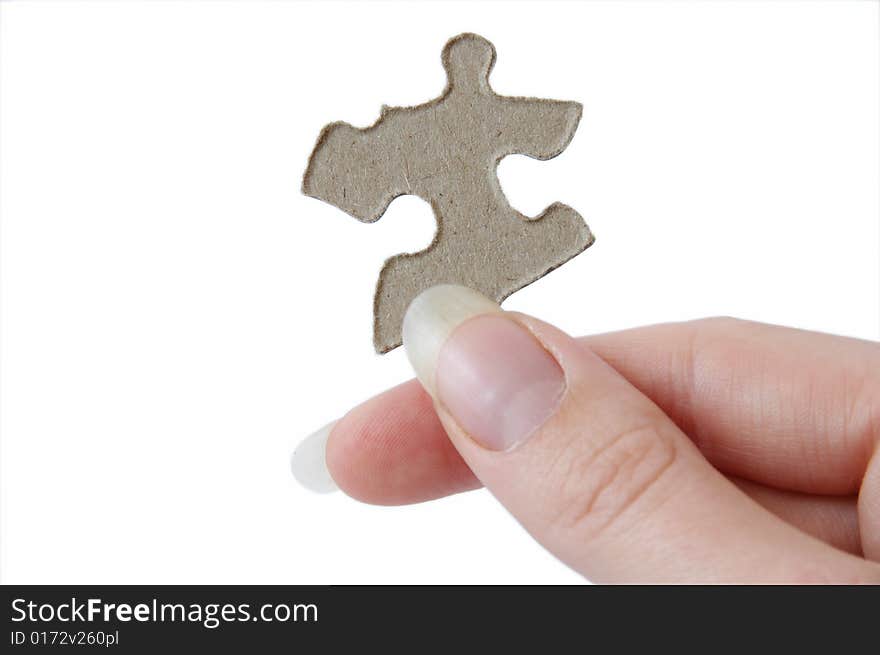 One jigsaw piece held in a hand, ready to solve a puzzle. One jigsaw piece held in a hand, ready to solve a puzzle