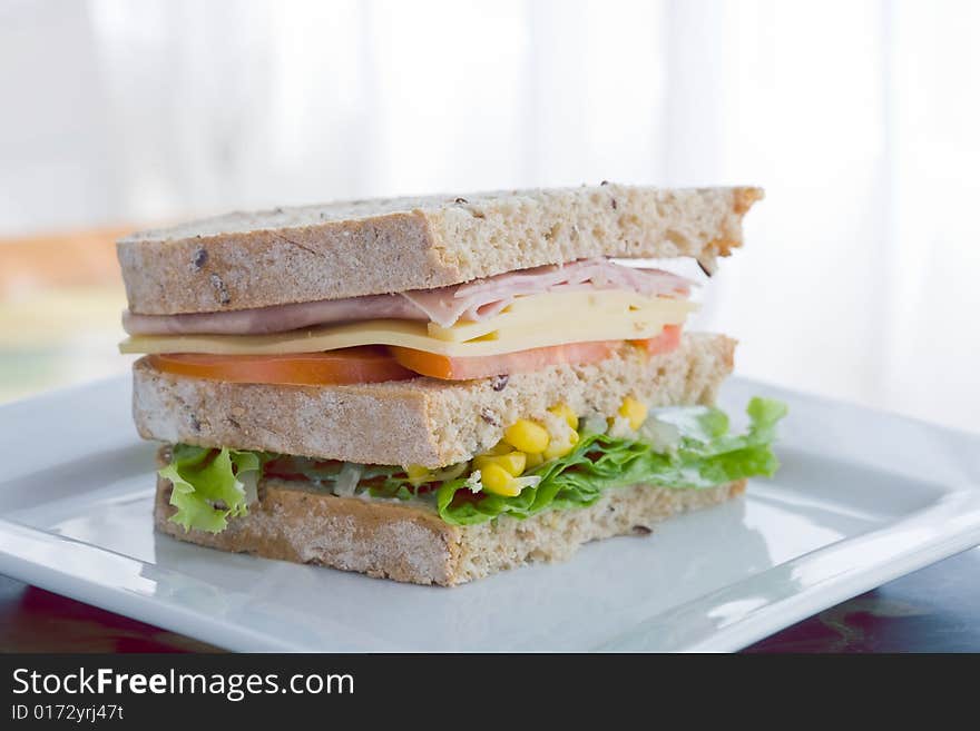 Submarine sandwich with whole grain bread on wood platter