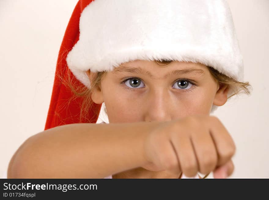 A little girl with christmas hat showing punch