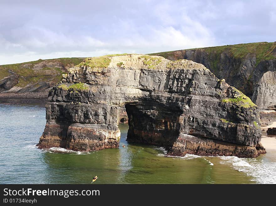 A canoeist at the virgin rock in ballybunion ireland as seen from the cliffs. A canoeist at the virgin rock in ballybunion ireland as seen from the cliffs