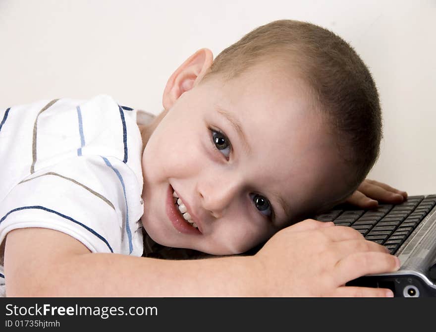 Little boy lying on laptop