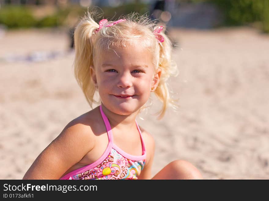 Little girl sitting in the sand. Little girl sitting in the sand