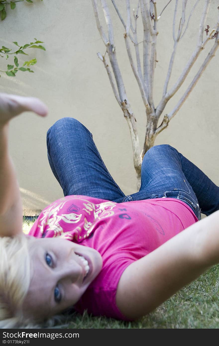 Happy Beautiful Woman Lying In The Garden