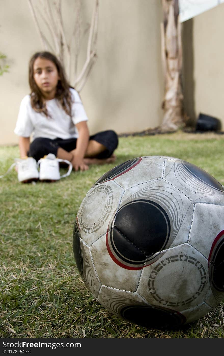 Close up of football and boy sitting on background