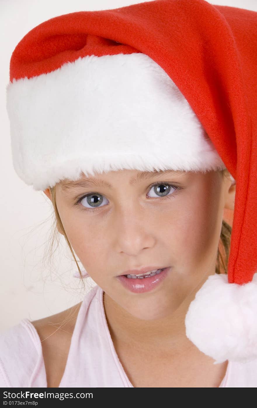 A smiling little girl wearing christmas hat