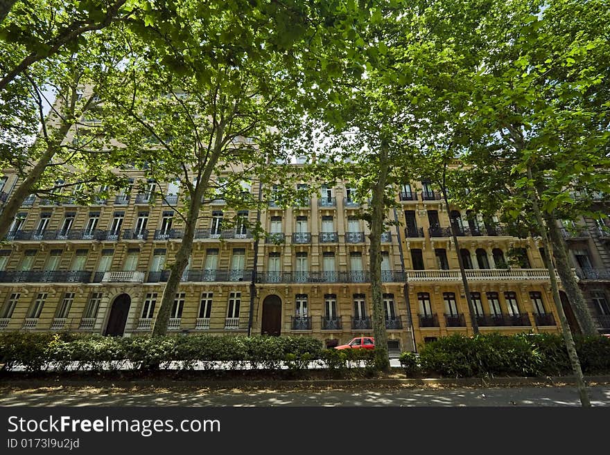 Wide angle view of a French building with trees in front. Wide angle view of a French building with trees in front.