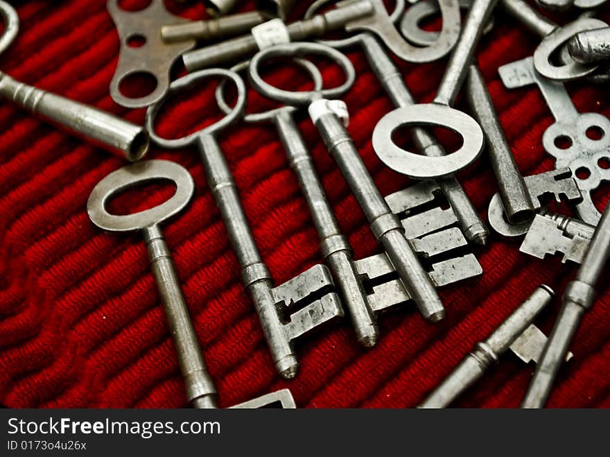 Old vintage metalic keys on a red cloths. Old vintage metalic keys on a red cloths