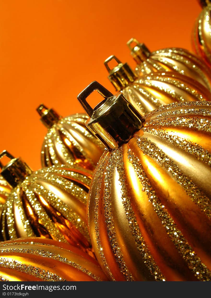Gold Christmas decoration, gold balls on orange background. Gold Christmas decoration, gold balls on orange background